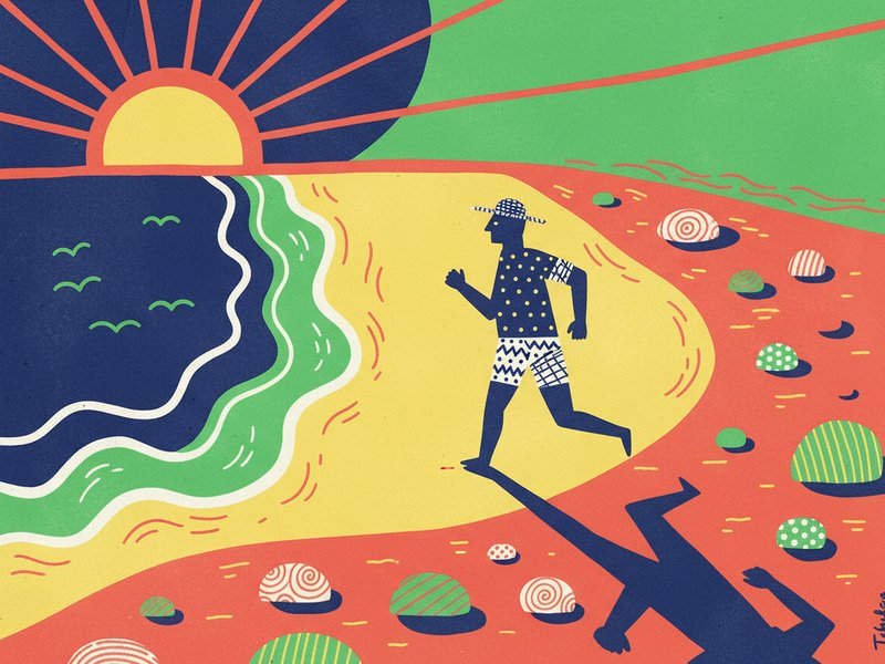 Man jogging on the beach at sunrise top down with long shadows